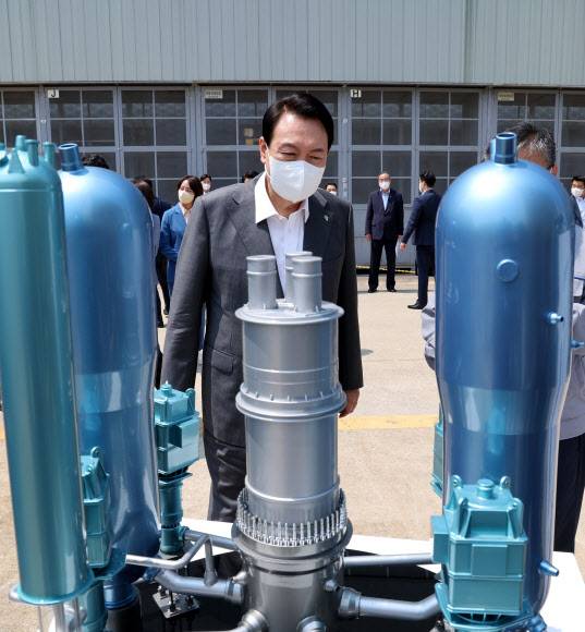 윤석열 대통령이 22일 경남 창원시 두산에너빌리티에서 한국형원전 APR1400의 축소 모형을 주의깊게 살펴보고 있다. 연합뉴스