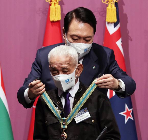 윤석열 대통령이 6?25전쟁 72주년을 하루 앞둔 24일 서울 중구 신라호텔 다이너스티홀에서 열린 국군 및 유엔군 참전유공자 위로연에서 UN참전용사 베니토 주니오 카마조(94, 필리핀)씨에게 ‘평화의 사도’ 메달을 수여하고 있다. 대통령실사진기자단