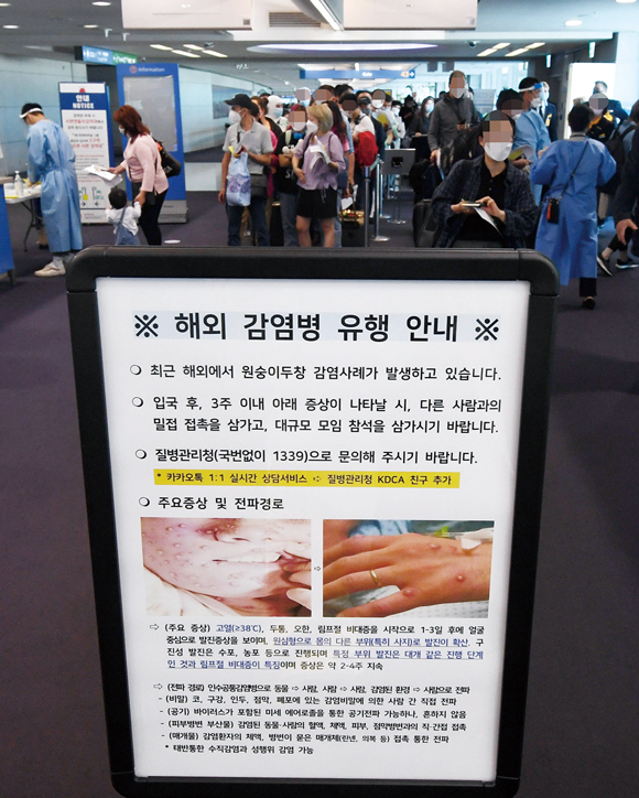 5월27일 인천국제공항에서 검역 대기 중인 승객들 앞에 원숭이두창 안내문이 세워져 있다.ⓒ연합뉴스