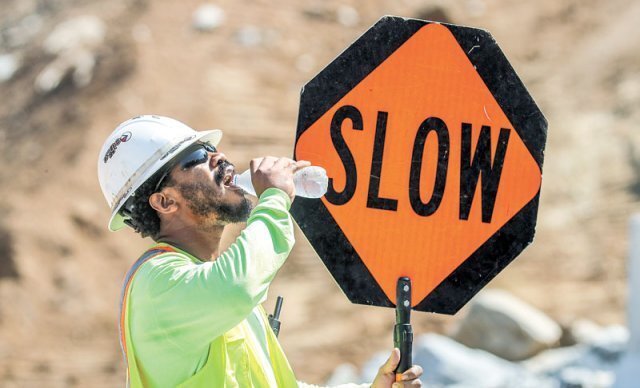 17일(현지 시간) 미국 애틀랜타의 한 고속도로 공사장에서 차량 통제 업무를 하는 근로자가 더위를 식히기 위해 물을 마시고 있다. 애틀랜타=AP 뉴시스