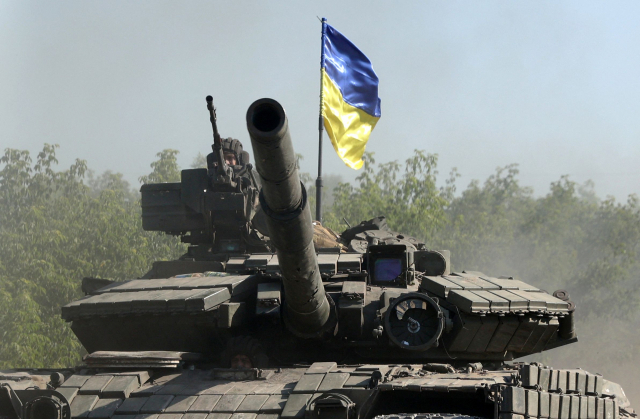 우크라이나군이 지난 21일(현지시간) 동부 돈바스 지역의 도로에서 탱크를 몰고 이동하고 있다. AFP=연합뉴스