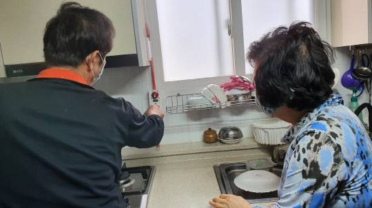 예산군 치매안심센터가 화재안전에 취약한 재가치매환자를 대상으로 안전관리 강화를 위해 가스안전장치 '가스타이머콕'을 설치해 주고 있다.사진=예산군 제공