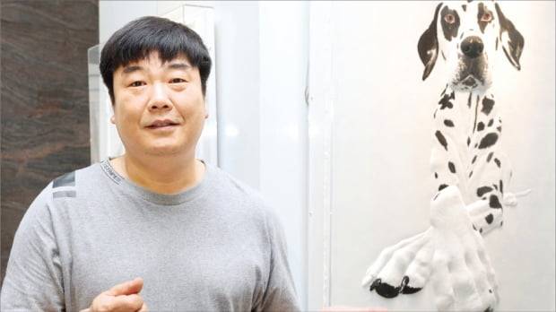 주후식 작가가 지난 24일 서울 중림동 한경갤러리에 전시한 작품 ‘달마시안’을 설명하고 있다. 달마시안을 광각렌즈로 본 모습을 표현한 부조 작품이다.  이솔  한경디지털랩  기자