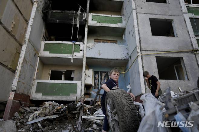 [체르니히우=AP/뉴시스] 19일(현지시간) 우크라이나 체르니히우에서 어린이들이 포격으로 파괴된 건물 앞에 모여 있다. 2022.06.20