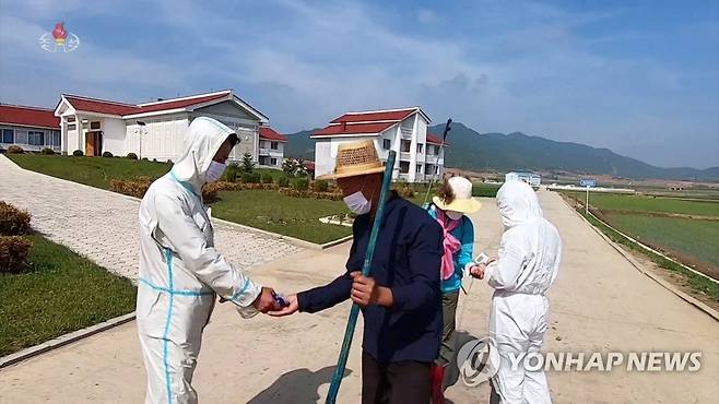 농장원들 체온측정하는 북한 방역원 (서울=연합뉴스) 북한 평안남도 문덕군 인민위원회 부장 리창룡은 6일 조선중앙TV에 출연해 현재 군에서 유열자(발열자) 발생수는 현저히 줄어들고있다고 전했다. 방역원들이 모내기 작업에 진입하는 농장원들에 대한 체온측정과 소독 사업을 하고있다. [조선중앙TV 화면] 2022.6.6 
    [국내에서만 사용가능. 재배포 금지. For Use Only in the Republic of Korea. No Redistribution] nkphoto@yna.co.kr