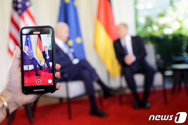 조 바이든 미국 대통령이 26일(현지시간) 독일 바이에른 알프스 엘마우성에서 열린 G7 정상회의에 도착해 올라프 숄츠 독일 총리와 얘기를 하는 모습이 휴대폰에 보이고 있다. © AFP=뉴스1 © News1 우동명 기자