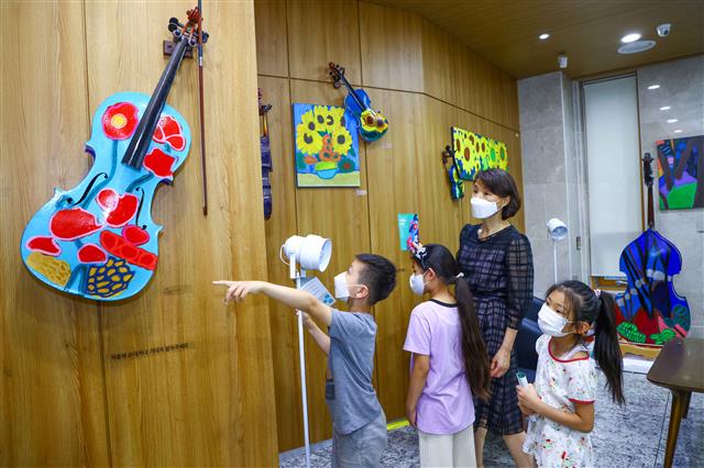 서울 서초구 구립반포도서관 방문자들이 고장 난 악기를 활용해 만든 미술 작품을 보고 있다.서초구 제공