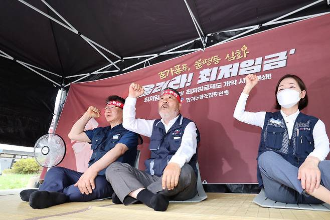 김동명 한국노총 위원장(가운데)이 27일 오후 세종시 정부세종청사 고용노동부 앞에서 최저임금 제도 개악 분쇄 및 대폭 인상을 위한 천막농성 돌입 기자회견을 마친 뒤 관계자들과 천막에 자리해 구호를 외치고 있다.(사진=연합뉴스)