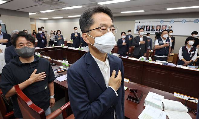 박준식 최저임금위원회 위원장(가운데)을 비롯한 사용자위원, 근로자위원, 공익위원들이 28일 세종시 정부세종청사 최저임금위원회 회의실에서 열린 제7차 전원회의에 참석해 국기에 경례하고 있다. 연합뉴스