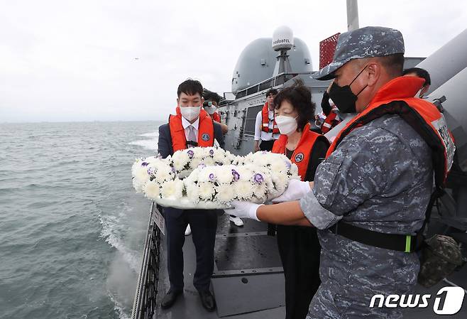 제2연평해전 승전 20주년인 29일 오후 서해상에서 해전 전사자 고(故) 윤영하 소령의 동생 윤영민씨와 모친 황덕희씨가 헌화를 하고 있다. 2022.6.29/뉴스1 © News1 김영운 기자