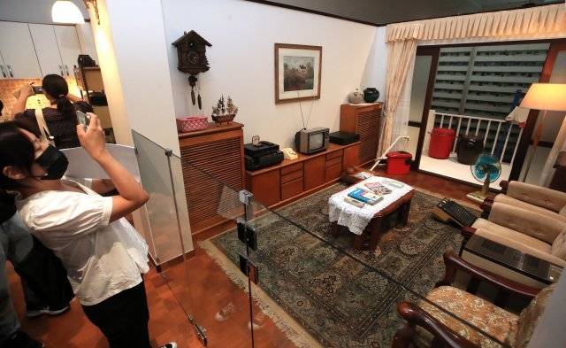 관람객이 서초삼호아파트 거실을 휴대폰으로 찍고 있다.