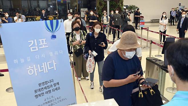 김포~하네다 항공노선 운항이 재개된 29일 서울 강서구 김포국제공항 국제선 탑승구에서 항공사 직원이 탑승객들을 안내하고 있다. 공동취재사진