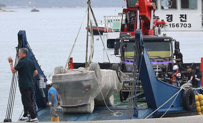 29일 오전 전남 완도군 신지면 송곡선착장 인근 방파제에서 경찰이 10ｍ 바닷속에 잠겨있는 조유나양 가족의 차량을 인양한 뒤 바지선에 싣고 이동하고 있다. 경찰은 실종된 조양의 가족과 차량을 찾기 위해 수중 수색하다 전날 가두리양식장 아래에 잠겨있는 차량을 발견했다. |연합뉴스