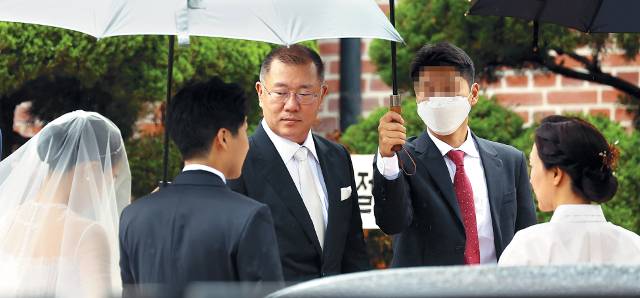 정의선(가운데) 현대차그룹 회장과 부인 정지선(오른쪽)씨가 27일 장녀 진희씨 결혼식이 열리는 서울 중구 정동제일교회에서 드레스를 입은 딸을 바라보고 있다. 연합뉴스