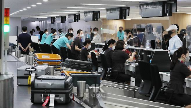 김포-하네다 항공노선 운항이 2년 3개월만에 재개된 29일 오전 서울 강서구 김포국제공항 국제선 출국장에서 탑승객들이 출국 수속을 밟고 있다. 이날 아시아나항공 OZ1085편과 대한항공 KE707편은 각각 오전 8시 40분과 오전 9시께 승객 50∼60여 명을 태우고 김포공항을 떠나 도쿄 하네다공항으로 향했다. 2022. 6. 29. [박형기기자]