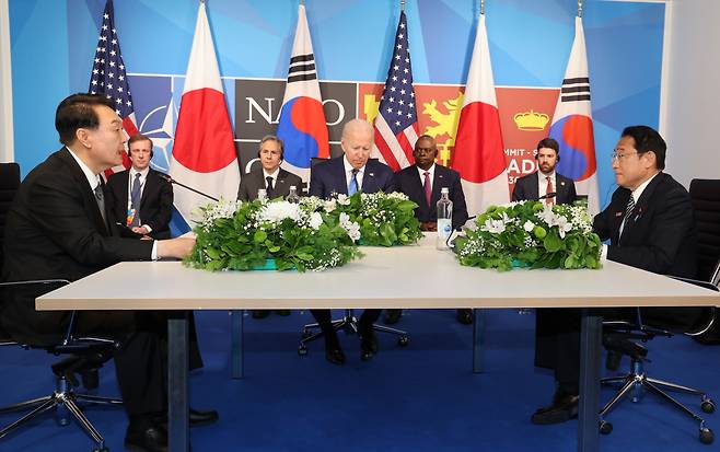 윤석열 대통령이 29일 스페인 마드리드 이페마(IFEMA) 컨벤션센터에서 열린 한미일 정상회담에서 조 바이든 미국 대통령, 기시다 후미오 일본 총리와 대화하고 있다. [연합]