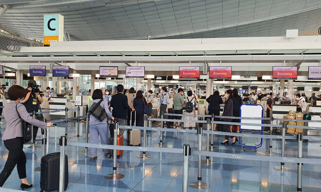 2년 3개월여 만에 서울 김포-도쿄 하네다 항공노선이 재개된 29일 하네다공항 아시아나항공 부스에서 한국을 방문하려는 승객들이 탑승 수속을 하고 있다. 하네다=강구열 특파원