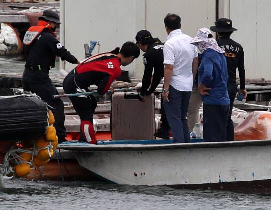 - 28일 오후 전남 완도군 신지면 송곡선착장 방파제로부터 80m 지점 가두리 양식장 아래에서 실종된 조유나(10) 양 가족의 차량으로 추정되는 아우디 승용차가 발견됐다. 경찰이 수중에 있는 차량 내에서 케리어를 건져 올리고 있다. 연합뉴스