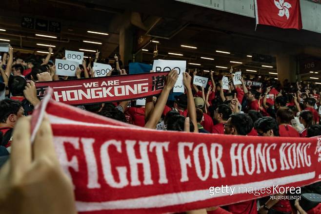 홍콩 축구팬들이 2019년 9월 10일 홍콩 스타디움에서 열린 2022 카타르월드컵 2차 예선 홍콩과 이란의 경기 시작 전 중국 국가가 울려퍼지자 등을 돌린 채 홍콩 민주화 지지 슬로건을 들어 보이고 있다. 게티이미지코리아
