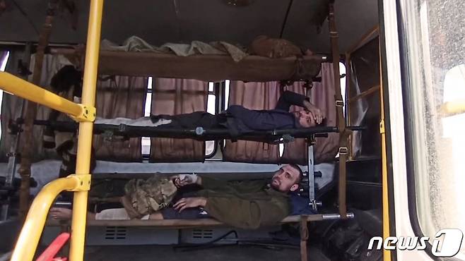 5월17일 (현지시간) 러시아 군에 점령된 마리우폴 아조우스탈 제철소를 떠나는 우크라이나 부상 병사들이 친러시아 군의 감시를 받으며 들것에 누워 차량을 타고 있다. © AFP=뉴스1 © News1 우동명 기자