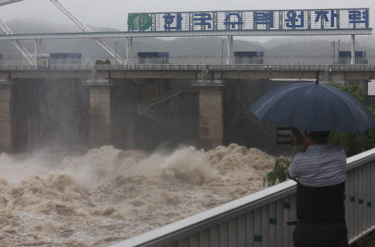 30일 하남시 팔당댐 근처에서 한 시민이 집중호우로 방류 중인 댐을 보고 있다.  연합뉴스