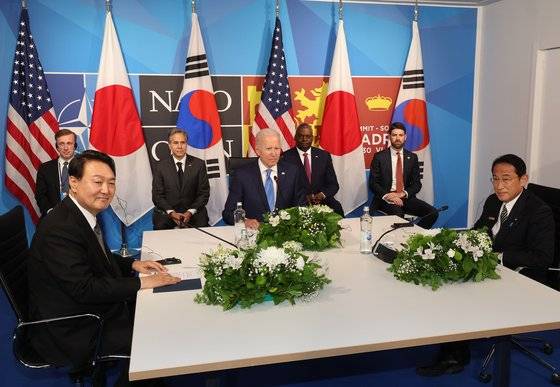 윤석열 대통령이 29일(현지시간) 스페인 마드리드 이페마(IFEMA) 컨벤션센터에서 열린 한미일 정상회의에서 조 바이든 미국 대통령, 기시다 후미오 일본 총리와 대화하고 있다. 연합뉴스