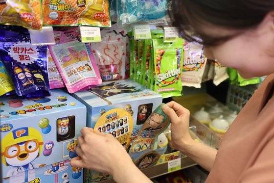편의점 직원이 토이캔디 상품을 보고 있다. [사진 CU]
