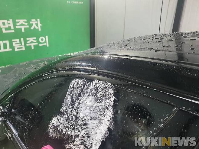 워시 미트를 이용해 차량을 세척하는 모습