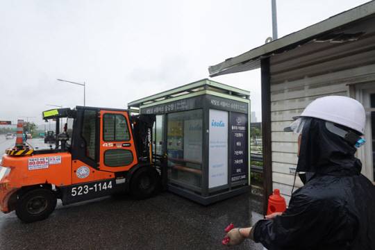 30일 오전 서울 반포대교 남단 세빛섬 인근 올림픽대로변에서 관계자들이 침수 우려가 있는 셔틀버스 승차장을 안전지대로 옮기고 있다. 연합뉴스