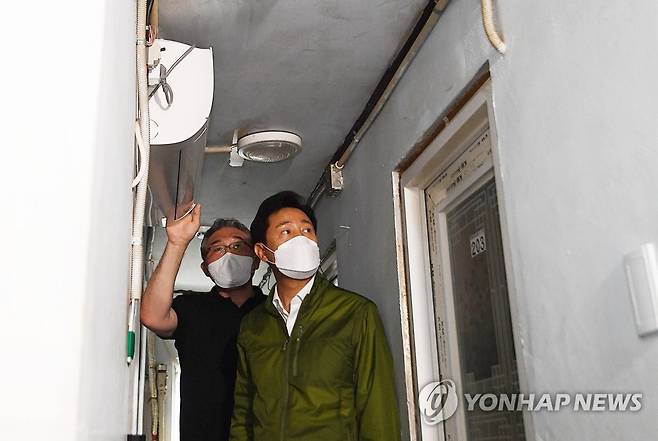 오세훈 시장, 돈의동 쪽방촌 방문 (서울=연합뉴스) 홍해인 기자 = 오세훈 서울시장이 29일 서울 종로구 돈의동 쪽방촌을 방문, 최영민 돈의동쪽방상담소 소장으로부터 쪽방촌에 설치된 에어컨에 관한 설명을 듣고 있다. 2022.6.29 [공동취재] hihong@yna.co.kr