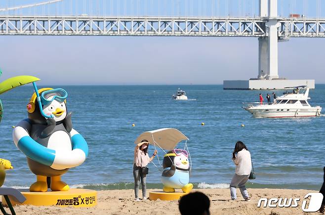 부산 수영구 광안리해수욕장을 찾은 시민들이 펭수 조형물 앞에서 기념사진을 찍고 있다. 2022.6.30/뉴스1 © News1 김영훈 기자