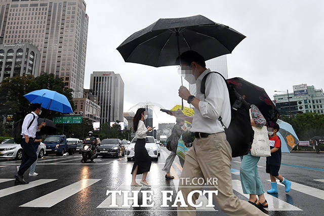 서울 종로구 광화문 네거리 일대의 시민들이 내리는 비에 우산을 쓴 채 발걸음을 재촉하고 있다. /남용희 기자