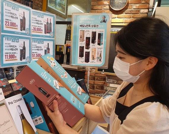 이마트24에서 모델이 이달의 와인을 살펴보고 있다. 이마트24 제공.