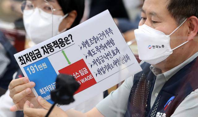 6월 16일 오후 정부세종청사 최저임금위원회 회의실에서 열린 제4차 전원회의에서 정문주 근로자위원이 최저임금 차등 적용 문제점을 적은 손팻말을 들어 보이고 있다. 이날 위원회가 최저임금 업종별 구분 적용을 표결에 부친 결과 부결됐다. 뉴스1