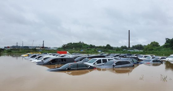 지난달 30일 오전 경기 남부 지역에 시간당 최대 50㎜ 넘는 폭우가 쏟아지면서 도로 침수와 가로수 전도 등의 피해가 잇따랐다. 사진은 침수 피해 입은 수원 중고차단지 모습. 연합뉴스