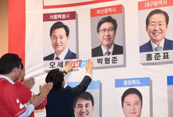 ▲이준석 국민의힘 대표를 비롯한 지도부가 6월 2일 서울 국회도서관 대회의실에 차려진 제18회 전국동시지방선거 개표상황실에서 오세훈 서울시장 사진에 스티커를 붙히고 있다.  /사진=뉴시스