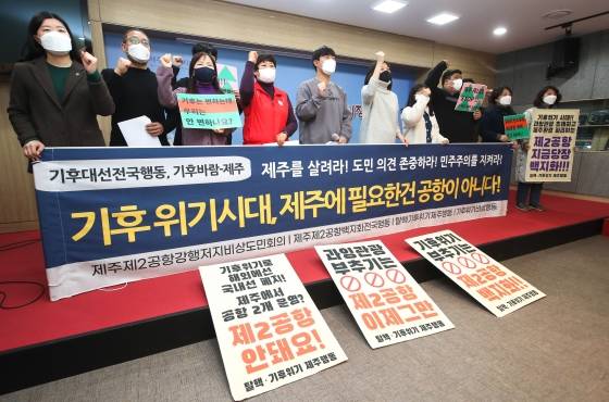 ▲ 제주 기후위기비상행동·제2공항강행저지비상도민회의·제주제2공항백지화전국행동·탈핵기후위기제주행동 관계자들이 2월 15일 제주도의회 도민카페에서 기자회견을 열어 제주 제2공항 사업 계획 취소 촉구 구호를 외치고 있다./사진=뉴시스