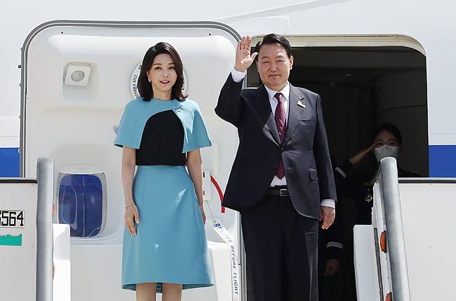 윤석열 대통령이 나토(북대서양조약기구) 정상회의 일정을 끝내고 6월 30일(현지시간) 귀국하기 위해 김건희 여사와 함께 스페인 마드리드 바라하스 국제공항에서 공군 1호기 탑승을 앞두고 손을 흔들고 있다.    연합뉴스