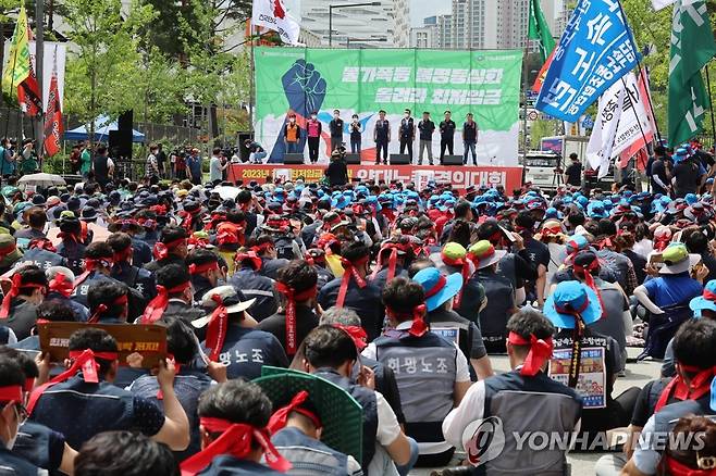 지난달 28일 최저임금 양대노총 결의대회 (세종=연합뉴스) 김주형 기자 = 28일 오후 정부세종청사 고용노동부 앞에서 열린 '최저임금 인상을 위한 양대노총 결의대회'에서 최저임금위원회에 참석하는 근로자위원들이 무대에 올라 발언하고 있다. 2022.6.28 kjhpress@yna.co.kr