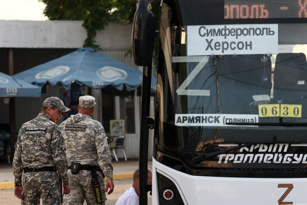 러시아 쿠로트나야 버스 정류장에서 크림반도의 심페로폴과 우크라이나의 헤르손을 오가는 버스 옆을 지나가고 있다. 사진=연합뉴스