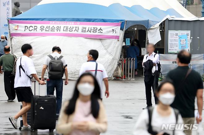 [서울=뉴시스] 조성우 기자 = 코로나19 신규 확진자가 1만463명으로 집계된 지난달 29일 오전 서울 중구 서울역에 마련된 임시선별검사소 앞을 시민들이 오가고 있다. 2022.06.29. xconfind@newsis.com