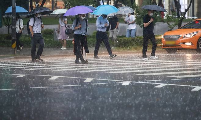 지난 23일 서울 서대문구 경찰청 인근에서 우산을 쓴 시민들이 이동하고 있다. 뉴시스