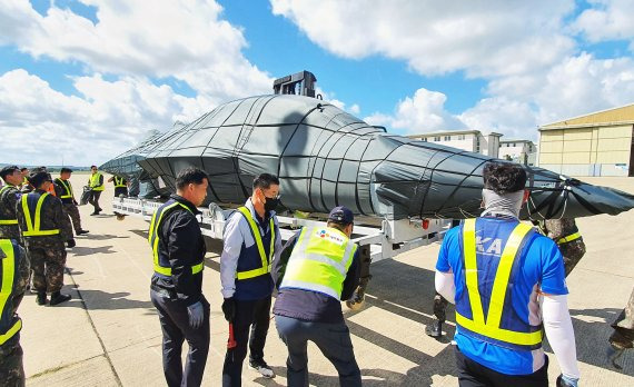 지난 6월 13일 영국 스탠스테드 공항에서 CJ대한통운 관계자들이 블랙이글스 항공기 T-50B의 환적 작업을 진행하고 있다. CJ대한통운 제공