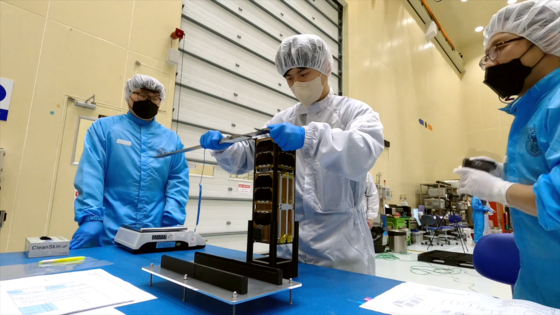 Researchers at Seoul National University check a satellite being loaded onto the KSLV-II. [KOREA AEROSPACE RESEARCH INSTITUTE]