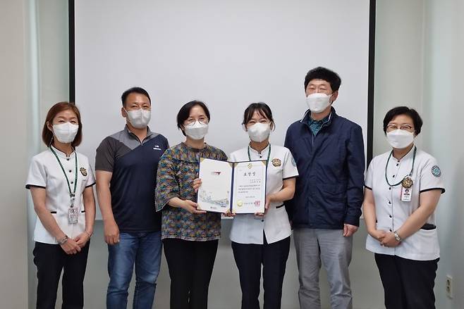 [서울=뉴시스]갑을녹산병원에서 주순남 간호부장(왼쪽에서 4번째)이 박영란 부산광역시 강서구 보건소 재택치료팀장(3번째)으로부터 부산시장 표창장을 전달받고 참석자들과 기념촬영을 하고 있다. (사진=KBI그룹 제공) *재판매 및 DB 금지