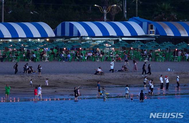 [제주=뉴시스] 우장호 기자 = 4일 오후 제주시 이호해수욕장을 찾은 시민과 나들이객들이 밤바람을 맞으며 더위를 식히고 있다. 기상청에 따르면 제주 북부지역은 지난달 26일 내려진 폭염특보가 9일째 이어지고 있다. 2022.07.04. woo1223@newsis.com