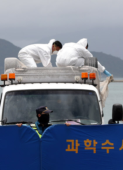 지난달 29일 오전 전남 완도군 신지면 송곡선착장 인근 방파제에서 경찰이 10ｍ 바닷속에 잠겨있는 조유나(10)양 가족의 차량을 인양한 뒤 유실방지망을 벗겨내고 있다. 연합뉴스