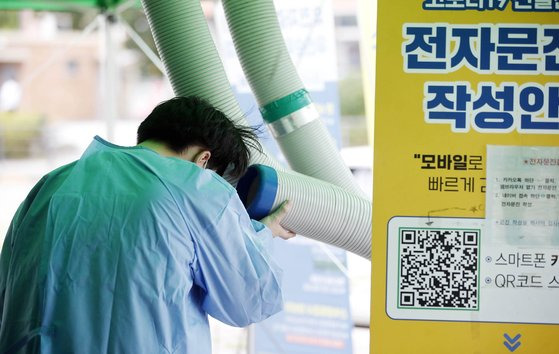 폭염주의보가 내려진 지난 4일 오후 광주 북구 상시선별진료소에서 보건소 의료진이 야외에 설치된 냉방기 앞에 서서 더위를 식히고 있다. 연합뉴스.