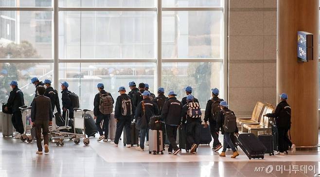 코로나19 해외 유입 확진자가 급증하고 있는 가운데 지난 1월10일 인천국제공항에 입국한 외국인 노동자들이 인솔자의 안내를 받아 이동하고 있다./사진=이기범 기자 /사진=이기범 기자 leekb@