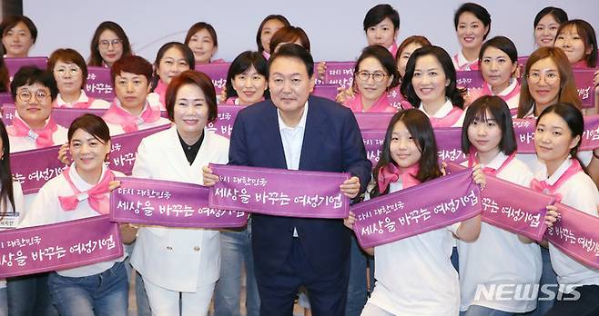 [서울=뉴시스] 전신 기자 = 윤석열 대통령이 5일 서울 여의도 중소기업중앙회관에서 열린 제1회 여성기업주간 여성경제인의 날 유공자 정부포상 수여식에서 참석자들과 기념촬영하고 있다. 2022.07.05. photo1006@newsis.com